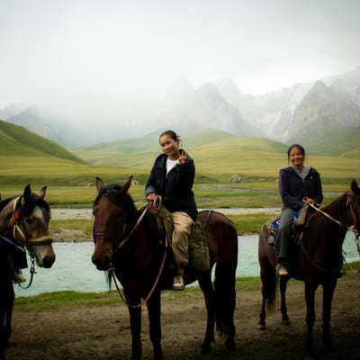 Horse riders in morning mist in the Kyrgyz mountains