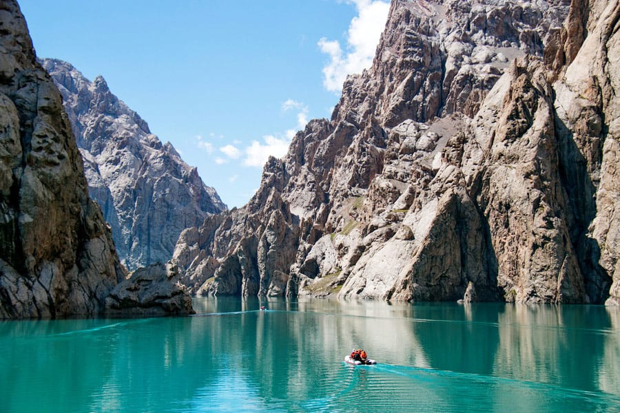 A boat on the turquoise water of Kel-Suu between sheer canyon walls